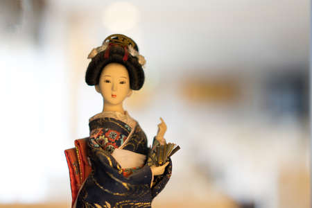 Japanese girl doll in national dress with beautiful face looking at camera.の写真素材