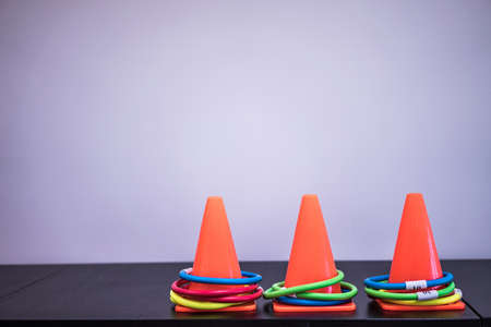 Orange cone and colorful hoop on the table in the playroom.の写真素材