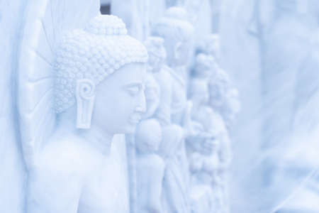 Buddha statue made of beautiful white limestone to be worshiped according to the faith.の写真素材