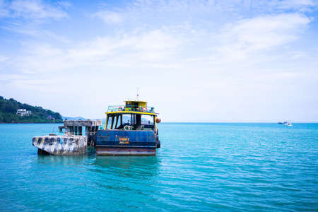 An island in the middle of the sea and an old ship moored in the se