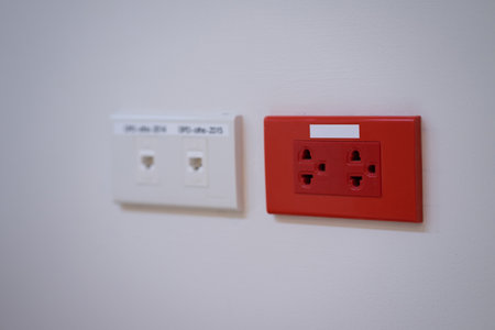 Power outlet socket on white floor wall.