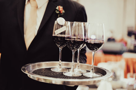 Wine glasses in a tray ready to be served by staff serving at a party in a luxury hotel.の写真素材