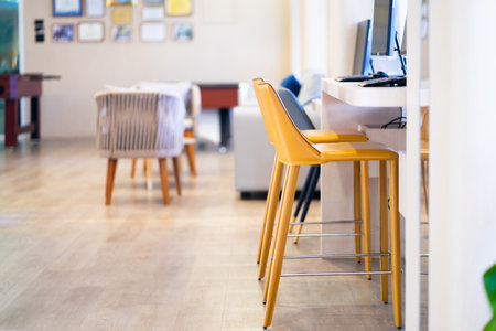 A bright yellow padded chair for typing in the computer in the internet room.