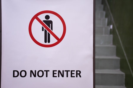 A white do not enter sign with an icon set before the stairs.