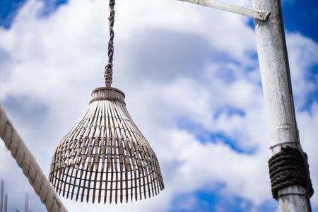 Lamp made from random fish traps bright sky background.の写真素材