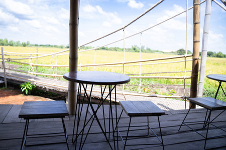 Round wooden table and wooden chairs To sit and sip coffee in the morning Green rice field...