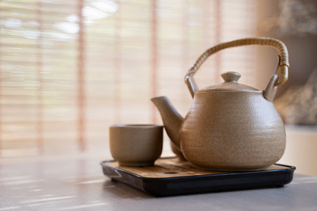 Teapot and tea cups, tea set on a tray placed on the table, blurred background, morning light.の写真素材