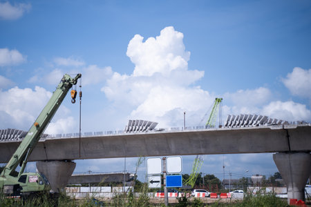 Cranes and tower cranes at the construction site of an elevated road, or elevated bridge. sky background.の写真素材