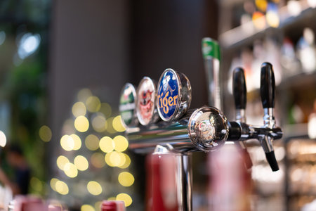 Bangkok, Thailand, December 19, 2023: Multi-brand beer dispensers in a Thailand pub with traditional...