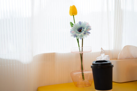 Flowers in a vase on the yellow tableware Decorative flowers on the dining table.の写真素材