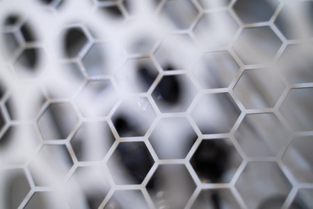 Close-up of the honeycomb-like carbon grid. car parts bokeh light background.の写真素材