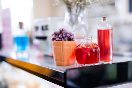 Glass bottles and jars with red juice on the table.の写真素材