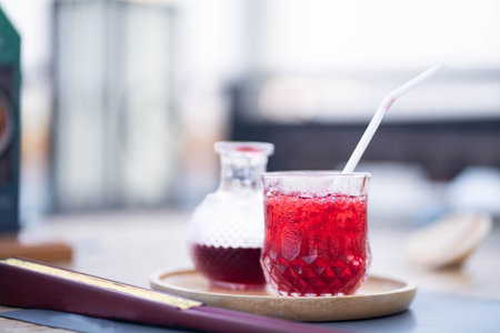 Refreshing red drink with ice ready to drink on a wooden tray on the dining table.