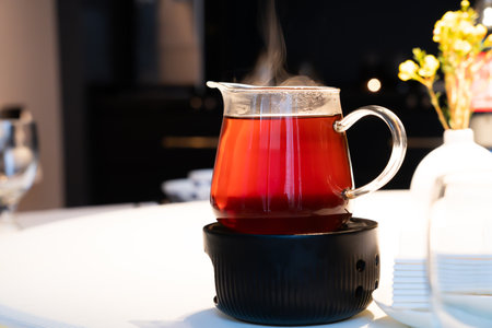 Hot tea in a glass with steam on the dining table.の写真素材