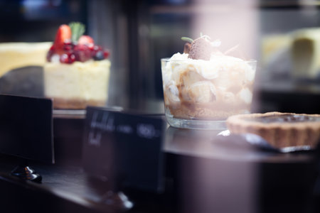 Banoffee cake with caramel sauce in a glass cup and pie Place in the bakery shop ,bokeh light background.の写真素材