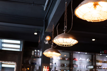 Vintage ceiling light, old metal ceiling light, warm orange light bulb. Modern style coffee shop interior decoration.の写真素材