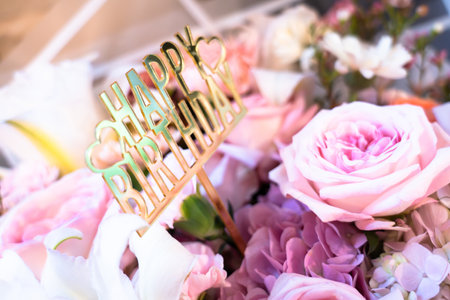 Close-up of happy birthday card on beautiful rose bouquet, bokeh light background.の写真素材
