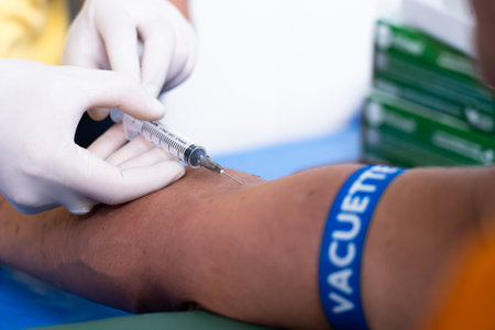 The doctor is taking a blood sample from the patient's arm for diagnosis.