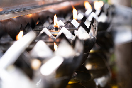 Stainless steel lamp and flame in oil lamp in temple.の写真素材