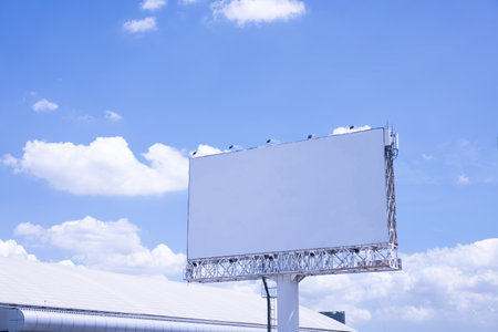 Large empty white billboard on a bright sky background.の写真素材
