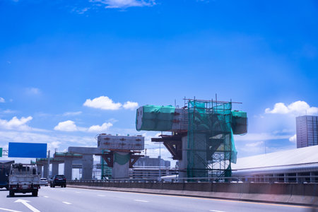 Construction site of transportation system, high-speed train overhead on pylons and tracks, efficient transportation development project, sky background.の写真素材
