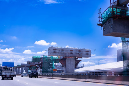 Construction site of transportation system, high-speed train overhead on pylons and tracks, efficient transportation development project, sky background.の写真素材