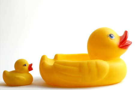 Two plastic yellow ducks in a lineの写真素材