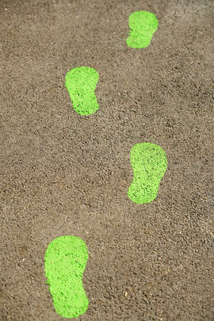Green footprints on pavementの写真素材