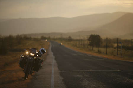 Motorcycle on a straight road at duskの写真素材
