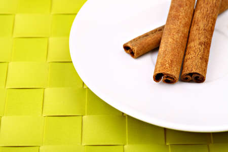 Color shot of sticks of cinnamon on a white plateの写真素材