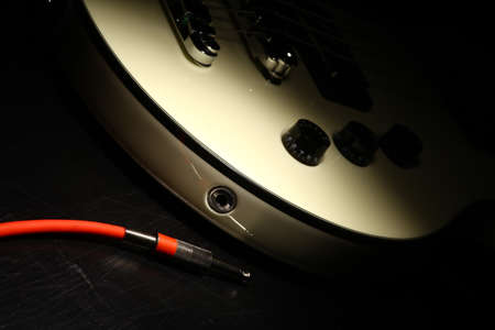 Detail on an electrical guitar and a red cord