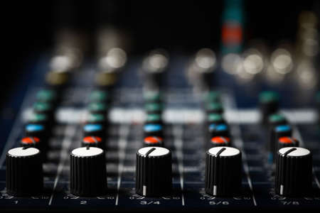 Detail of a music mixer desk with various knobs