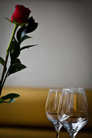 Fine restaurant dinner table place with two wine glasses and a roseの写真素材