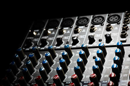 Detail of a music mixer desk with various knobs