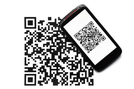 A mobile phone next to a QR code printed on paper
