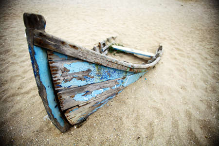 Color picture of an abandoned boat stuck in sand