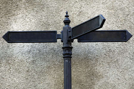 Color shot of some empty directional street signs on a pole.