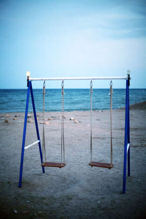 Two swings on a beach near the seaの写真素材