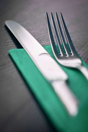 Fork and knife and a napkin on a tableの写真素材