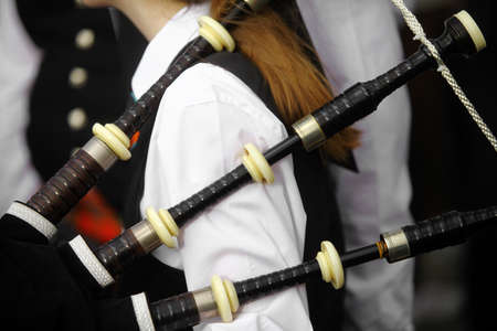 Color shot of a person holding a traditional bagpipe.
