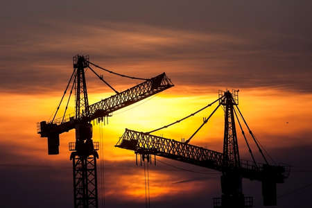Color picture of some cranes on a construction site, as dusk.の写真素材