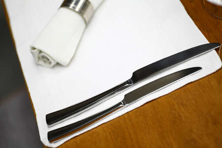 Two knives on a dinner table in a restaurant.