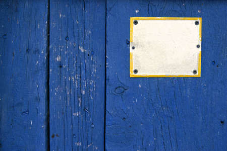 Color shot of an empty white sign on a blue wooden plank.の写真素材