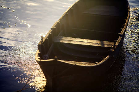 Color picture of a wooden boat on a river bank.の写真素材