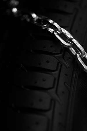 Vertical detail shot of some new snow chains on a car's tire.の写真素材