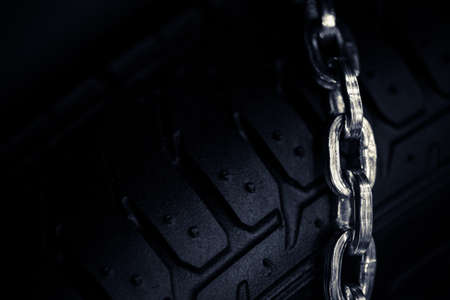 Horizontal detail shot of some new snow chains on a car's tire.の写真素材