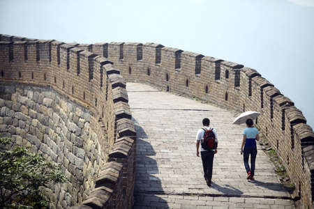 Mutianyu, China - September 19, 2014: Color horizontal shot of two persons walking The Great Wall of...