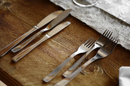 Shot with some forks and knives on a table in a restaurant.