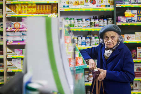 Bucharest, Romania - October 14, 2014: An elderly woman buys some medicine in a pharmacy in Bucharest, Romania.のeditorial素材