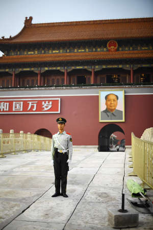 Beijing, China - September 25, 2014:  A soldier stands guard at Tiananmen Square, near a portrait of Mao Zedong, in Beijing, China.のeditorial素材